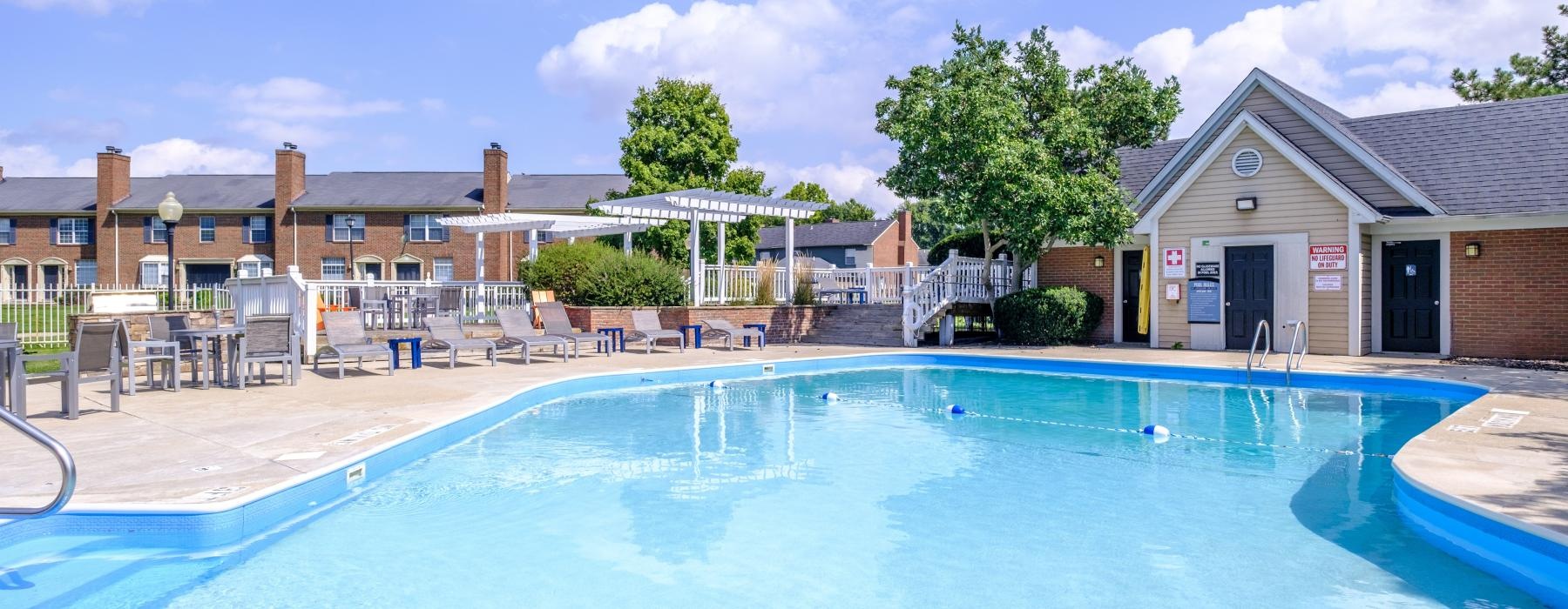 a large swimming pool with poolside lounge chairs and a grilling area