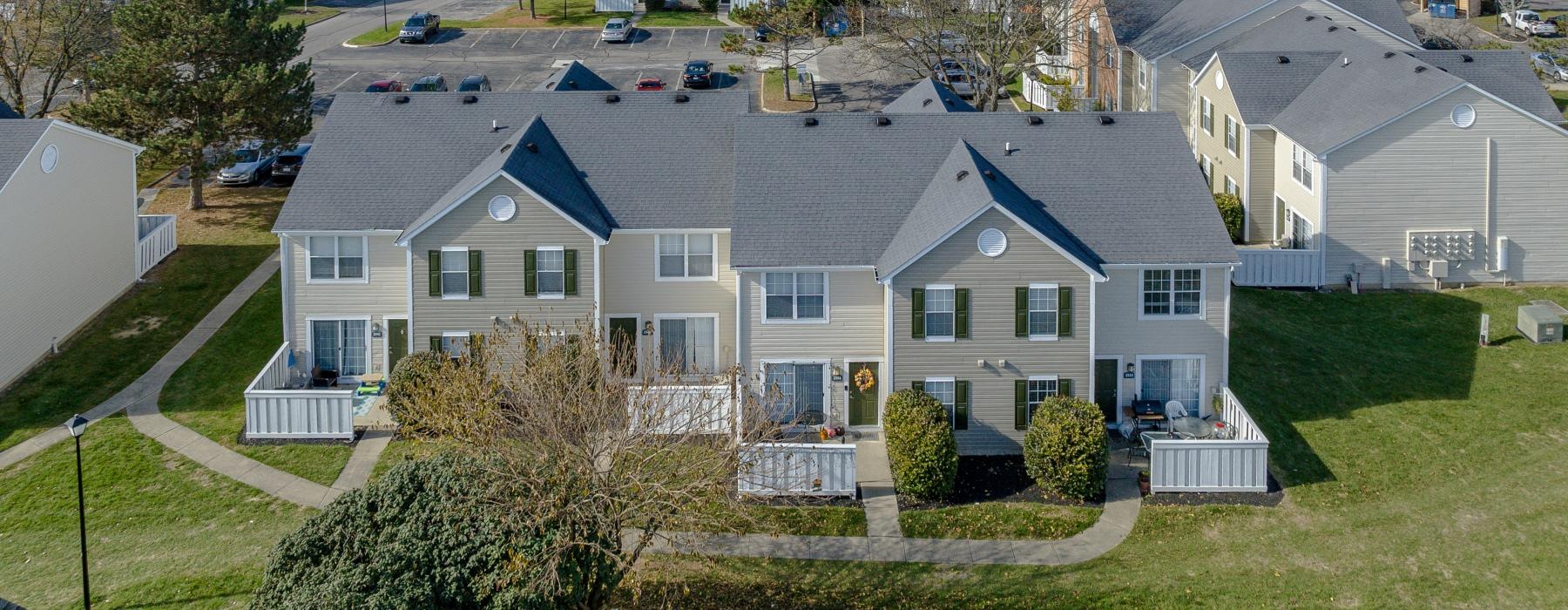 a beautiful aerial photo of an apartment property with numerous buildings, trees, and manicured landscaping