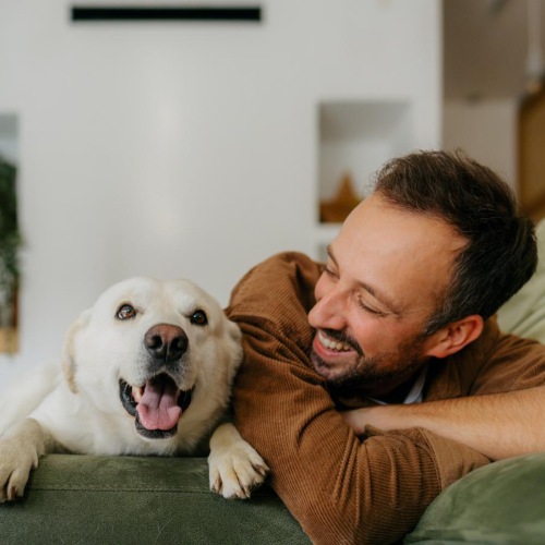 a man and a dog lying on a couch